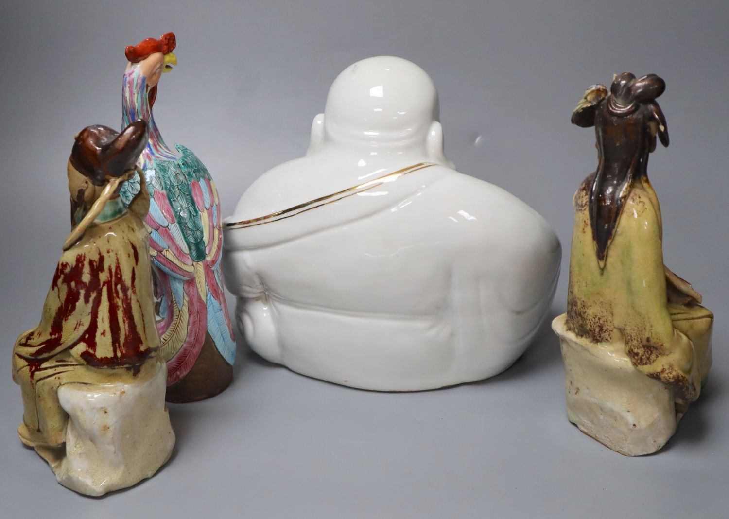 Four Chinese ceramic figures including Budai, 23cm, an enamelled phoenix, 24cm and two Chinese earthenware seated figures